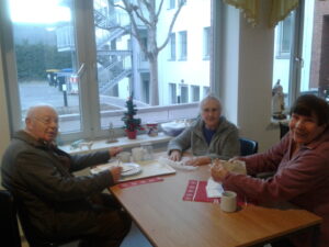 drei Bewohner*innen frühstücken an einem Tisch